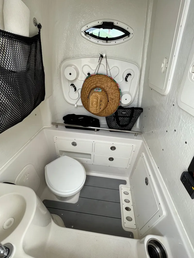 Slide: The Image of 2023 Sailfish 290 CC boat interior with toilet and storage. - 9