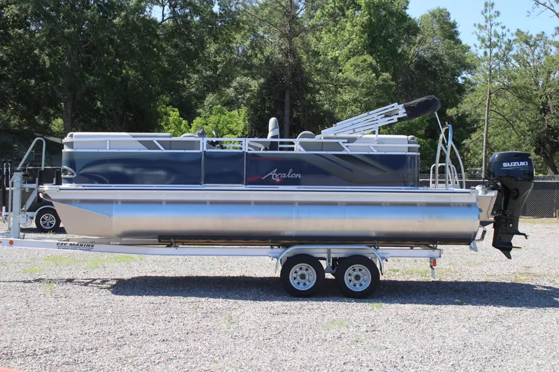 The Image of 2024 Avalon VENTURE QUAD LOUNGER pontoon boat on trailer, parked outdoors. - 0