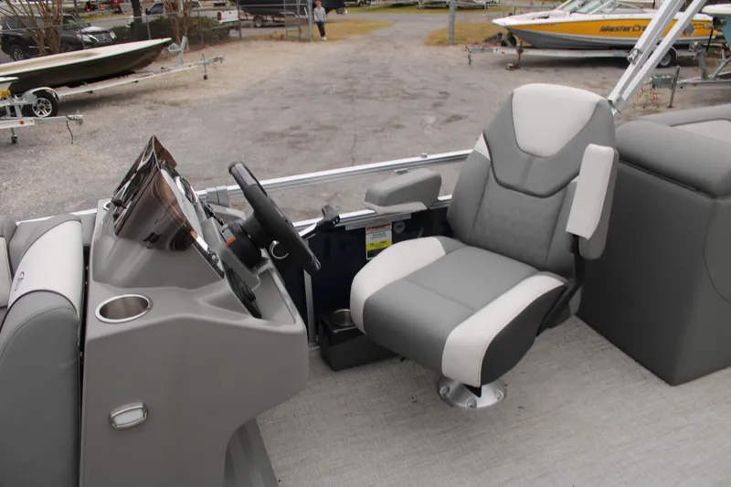 Slide: The Image of 2024 Avalon VENTURE QUAD LOUNGER boat interior with captain's chair and steering console. - 11