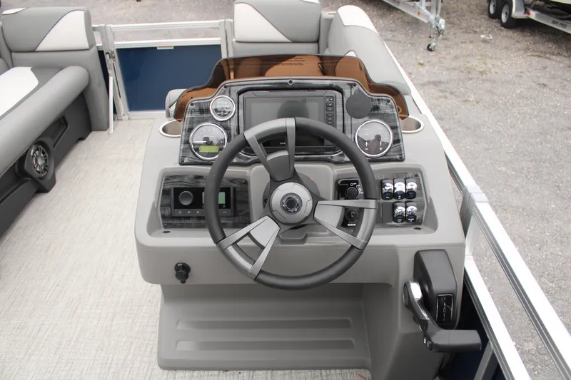 Slide: The Image of 2024 Avalon VENTURE QUAD LOUNGER boat dashboard with steering wheel and control panel. - 12