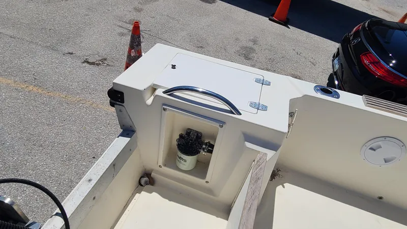 Slide: The Image of 1988 Mako 20 Center Console boat interior with storage compartment and fuel filter. - 21
