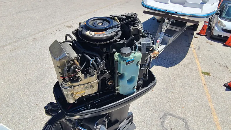 Slide: The Image of 1988 Mako 20 Center Console boat engine close-up, showing detailed components and trailer in background. - 29