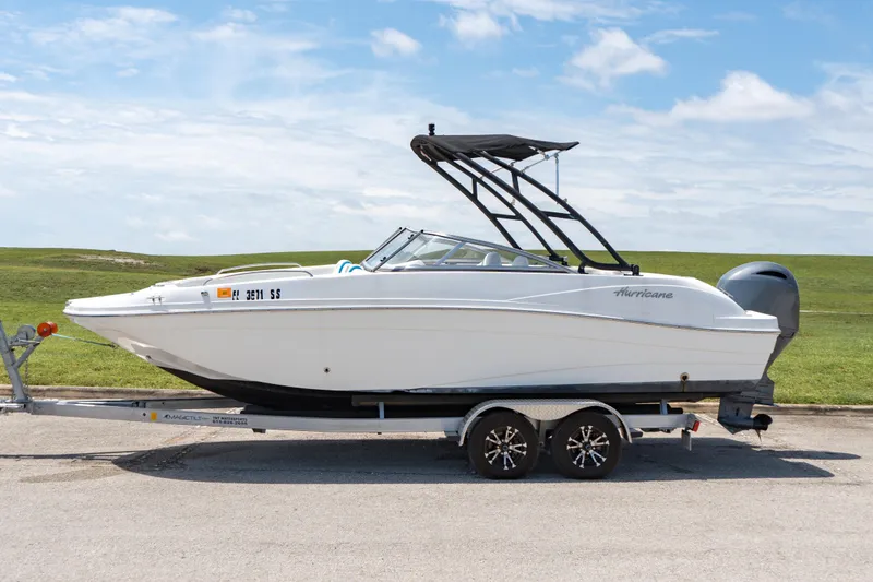 Slide: The Image of 2020 Hurricane 217 SD boat on a trailer against a scenic backdrop. - 1