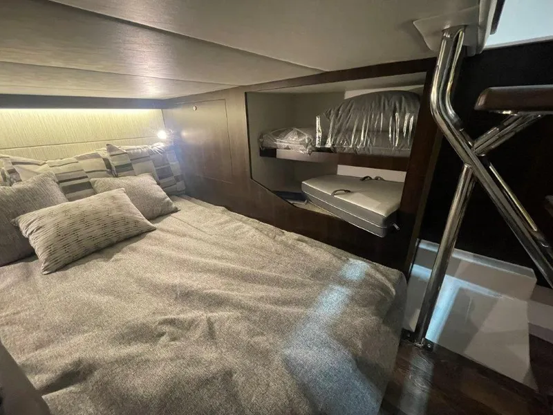 Slide: The Image of 2023 Cruisers Yachts 38 GLS OB cabin interior with bed and storage shelves. - 23