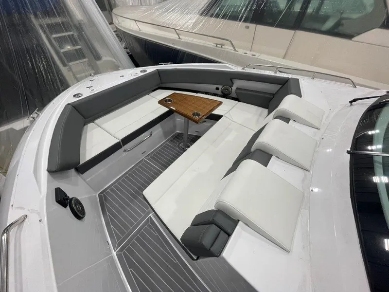Slide: The Image of 2023 Cruisers Yachts 38 GLS OB boat interior with white and gray seating and wooden table. - 35