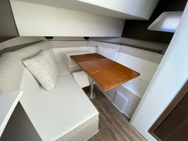 Slide: The Image of 2023 Cruisers Yachts 38 GLS OB interior cabin with dining table and cushioned seating. - 6