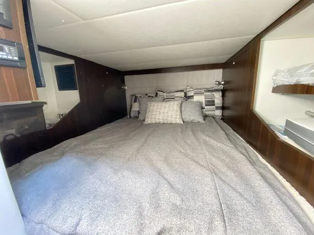 Slide: The Image of 2023 Cruisers Yachts 38 GLS OB cabin bed with gray bedding and pillows. - 8