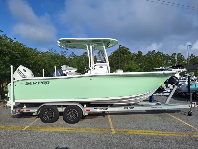 Slide: The Image of 2020 Sea Pro 219 Center Console boat on a trailer in a parking lot. - 2