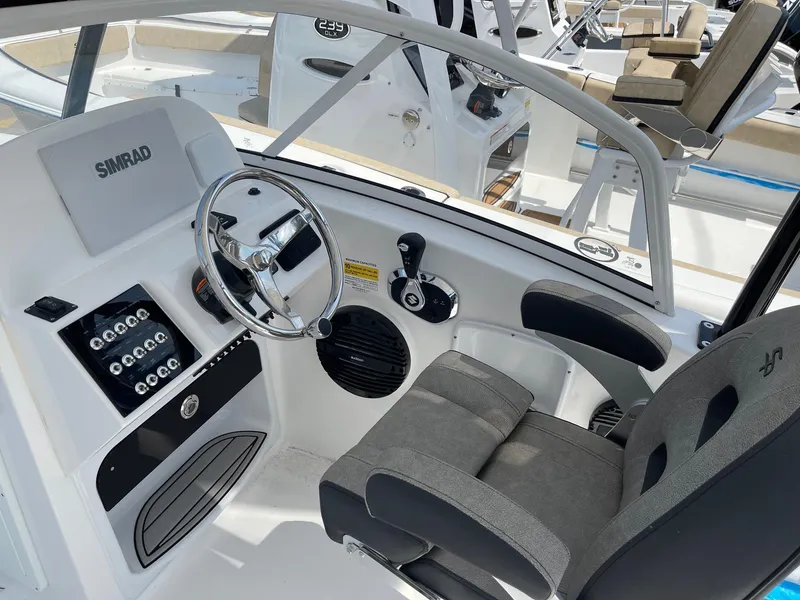 Slide: The Image of 2024 Sea Pro 240 Dual Console boat cockpit with steering wheel and control panel. - 4