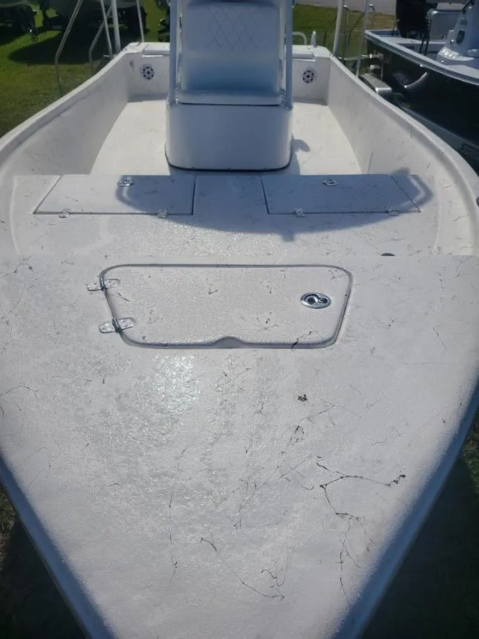 Slide: The Image of 2024 Blazer Bay 2400 boat with white cushioned seating and steering wheel. - 3