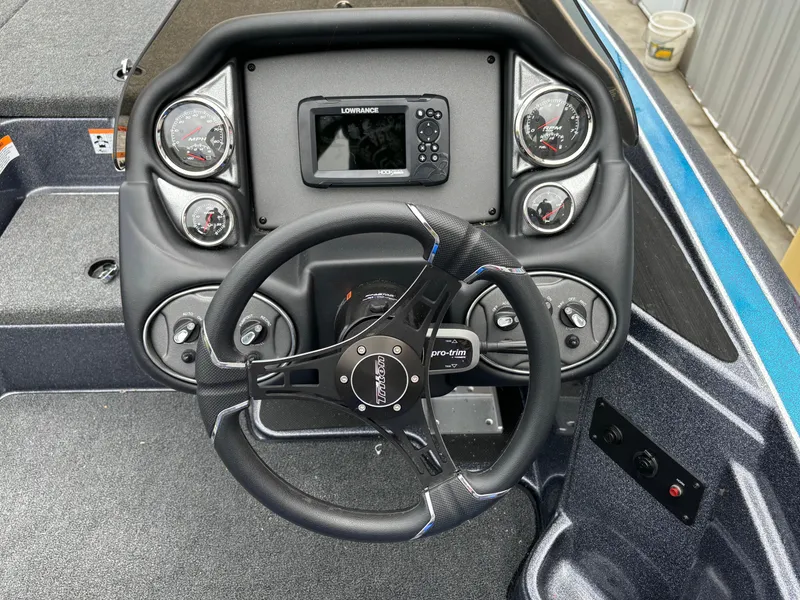 Slide: The Image of 2024 Triton 19 TrX boat dashboard with steering wheel and Lowrance display. - 11
