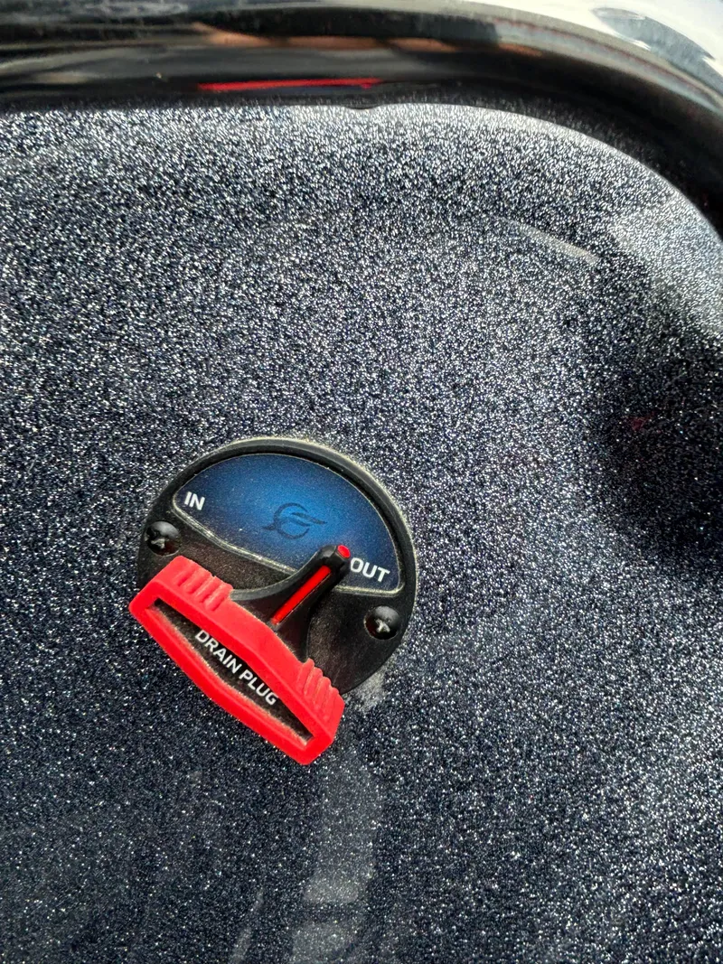 Slide: The Image of 2024 Triton 19 TrX boat drain plug control with red handle. - 14
