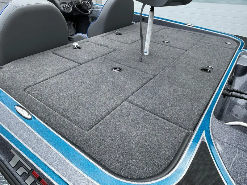 Slide: The Image of 2024 Triton 19 TrX boat deck with storage compartments and seating. - 15