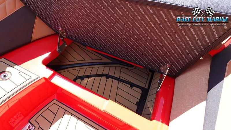 Slide: The Image of 2024 Nautique Super Air Nautique G23 storage compartment with Race City Marine branding. - 13