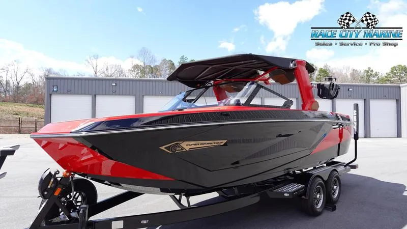 Slide: The Image of 2024 Nautique Super Air Nautique G23 boat in red and black on a trailer. - 2