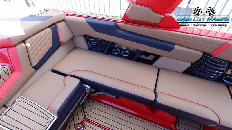 Slide: The Image of 2024 Nautique Super Air Nautique G23 interior with tan and red upholstery, Race City Marine logo. - 20