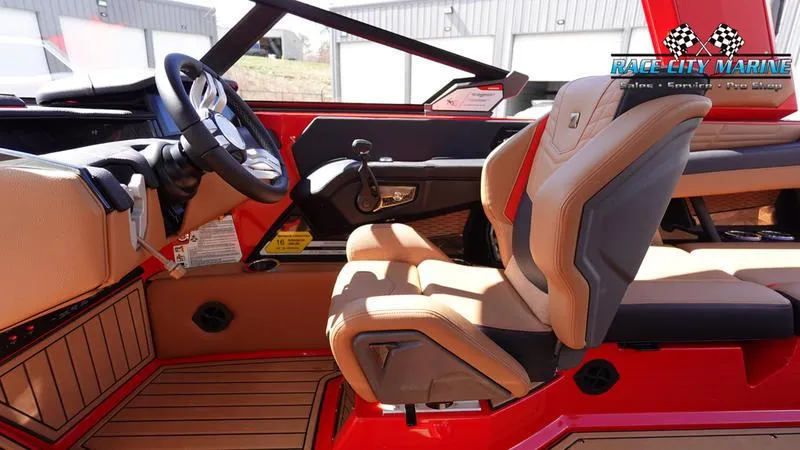 Slide: The Image of 2024 Nautique Super Air Nautique G23 interior with tan and black seating, steering wheel, and dashboard. - 30