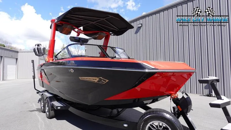 Slide: The Image of 2024 Nautique Super Air Nautique G23 boat in black and red, parked on a trailer. - 34
