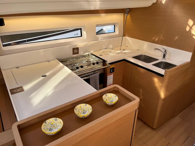 Slide: The Image of Modern kitchen area in 2024 Jeanneau Sun Odyssey 440 yacht with stove, sink, and counter space. - 2