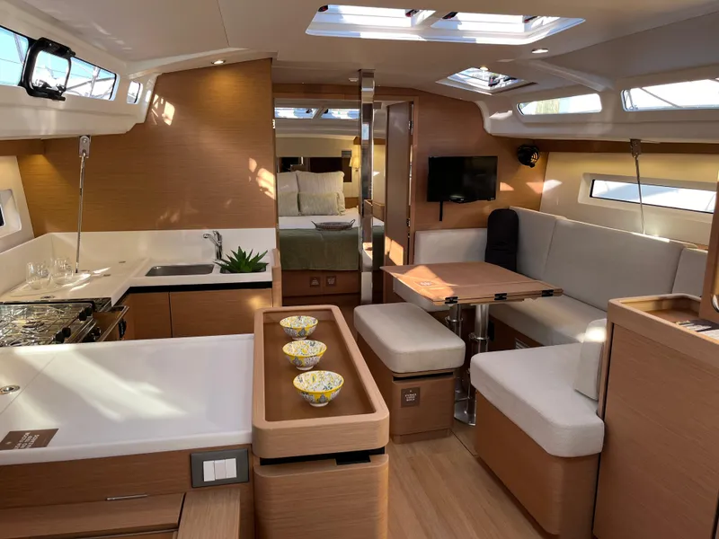 Slide: The Image of Interior of 2024 Jeanneau Sun Odyssey 440 sailboat with modern kitchen and dining area. - 7