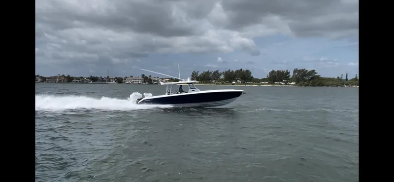 Slide: The Image of 2024 Bahama 41' Open Fisherman GT cruising on water under cloudy skies. - 14