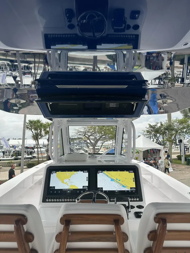 Slide: The Image of 2024 Bahama 41' Open Fisherman GT helm with dual navigation screens and wooden seats. - 7