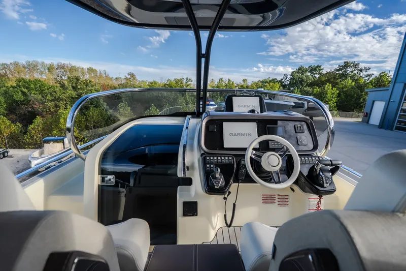 Slide: The Image of 2024 Invictus GT320S boat cockpit with Garmin navigation, surrounded by lush greenery. - 21