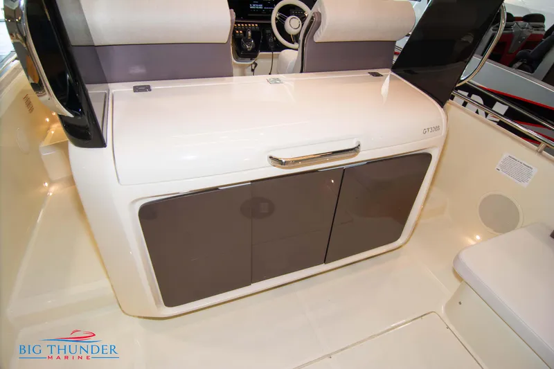 Slide: The Image of 2024 Invictus GT320S boat interior with storage cabinets and seating, Big Thunder Marine logo. - 21