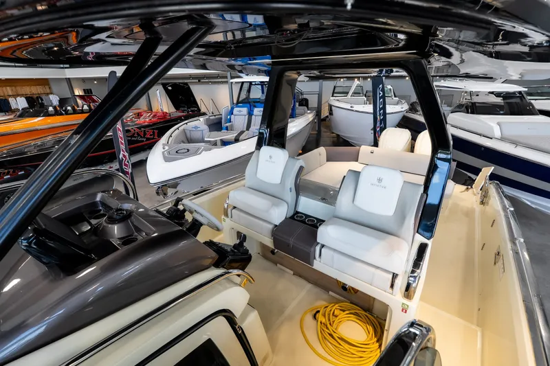 Slide: The Image of 2024 Invictus GT320S luxury boat interior with white seating in showroom. - 34