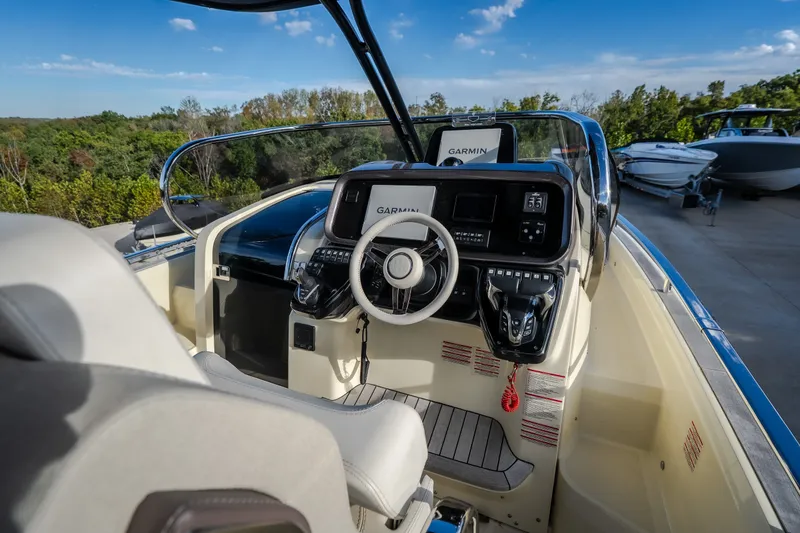 Slide: The Image of Cockpit of 2024 Invictus GT320S boat with Garmin navigation system, surrounded by lush greenery. - 18