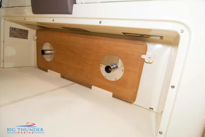 Slide: The Image of 2024 Invictus GT320S storage compartment with wooden panel and metal fixtures. - 49