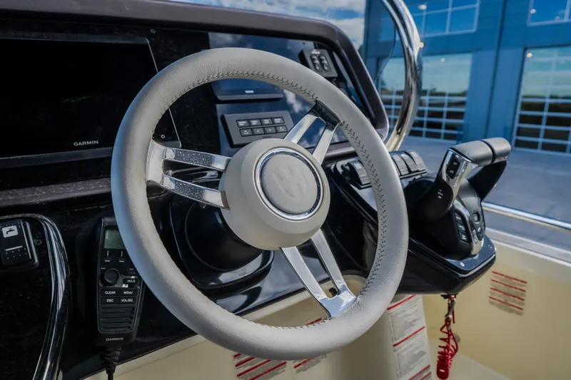 Slide: The Image of 2024 Invictus GT320S boat steering wheel and control panel close-up. - 46