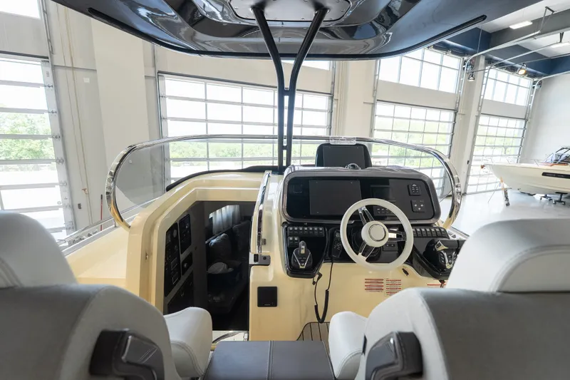 Slide: The Image of 2024 Invictus GT320S boat cockpit with modern controls and steering wheel in a showroom. - 14