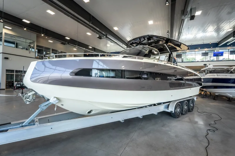 Slide: The Image of 2024 Invictus GT320S luxury boat displayed indoors on a trailer. - 8