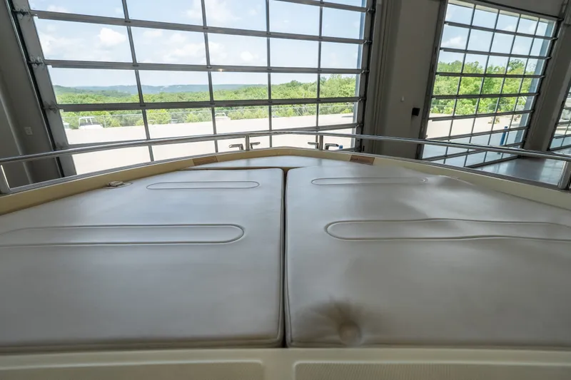 Slide: The Image of 2024 Invictus GT320S boat interior with cushioned seating, large windows, and scenic view. - 28