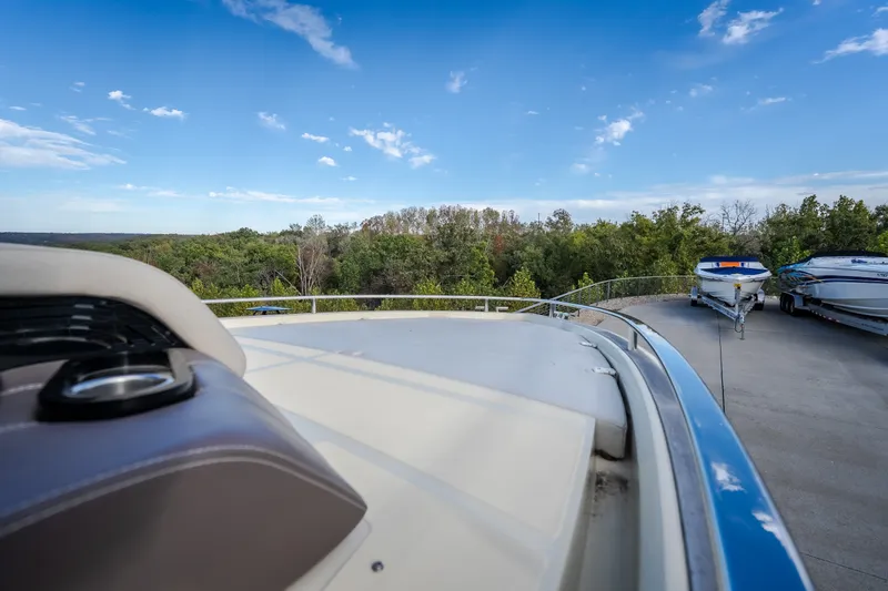 Slide: The Image of 2024 Invictus GT320S boat on trailer, surrounded by lush greenery and clear blue sky. - 32