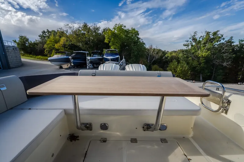 Slide: The Image of 2024 Invictus GT320S boat interior with wooden table and seating area. - 26