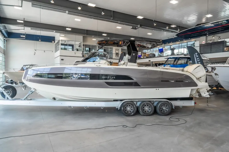 Slide: The Image of 2024 Invictus GT320S luxury boat displayed in a modern showroom. - 1