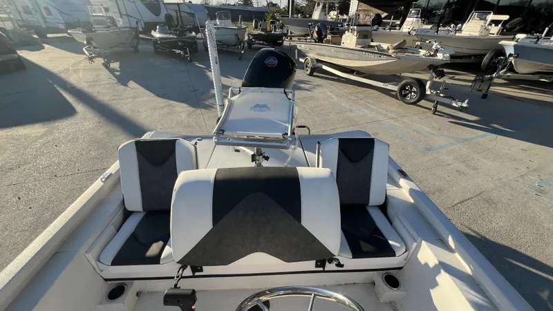 Slide: The Image of 2022 Vexus AVX2180CC boat interior with seating and steering wheel, parked in a marina. - 4