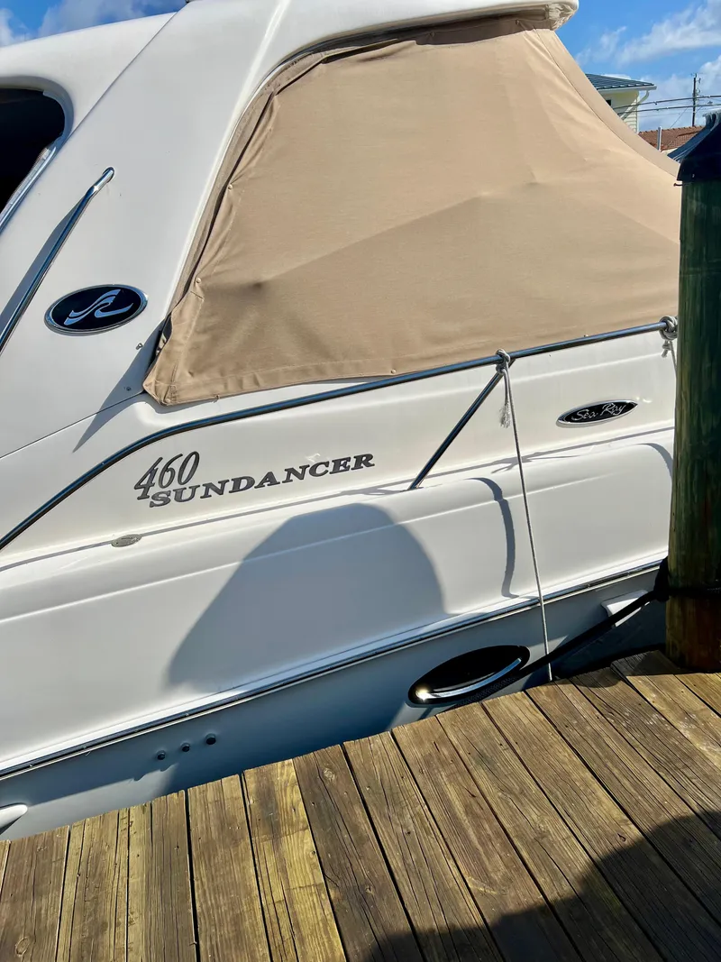 Slide: The Image of 2004 Sea Ray 460 Sundancer docked, beige cover, white hull. - 21