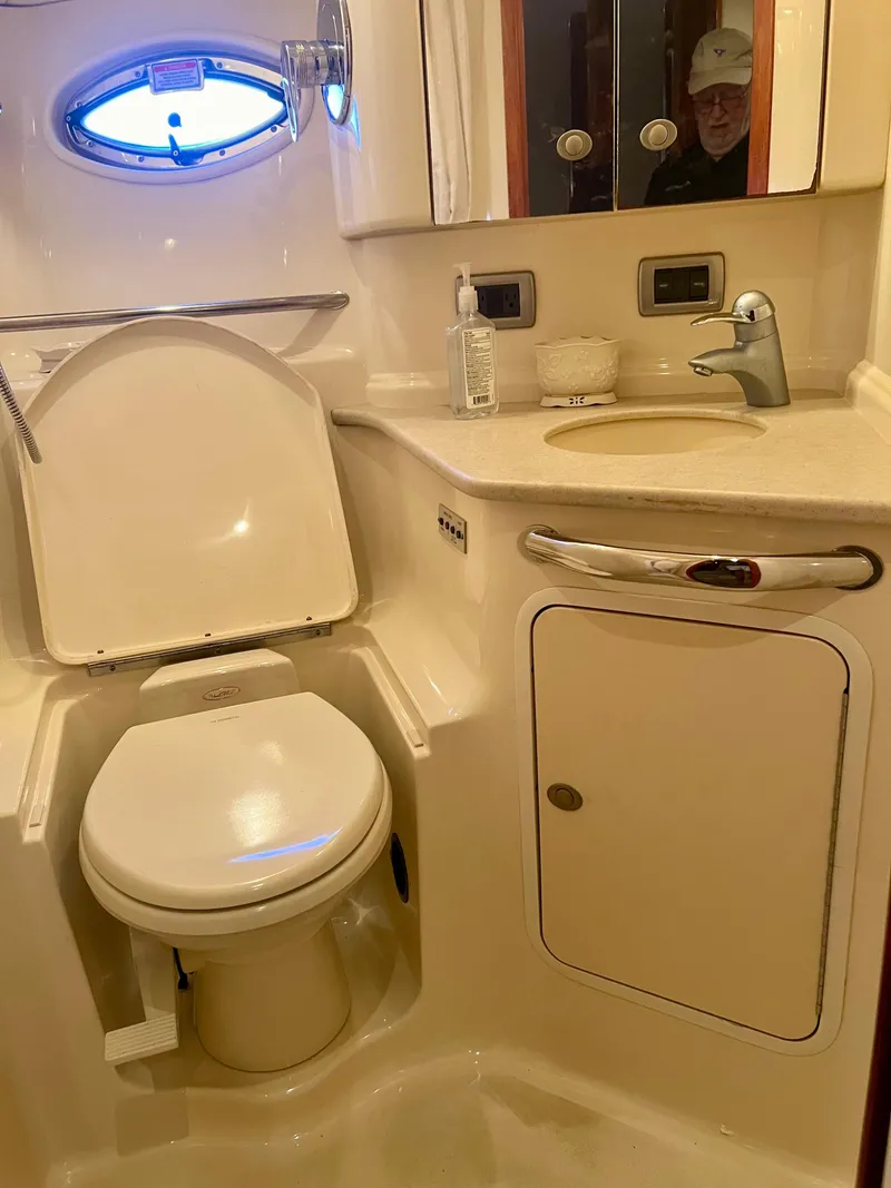 Slide: The Image of 2004 Sea Ray 46 Sundancer yacht bathroom with toilet, sink, and storage cabinet. - 22