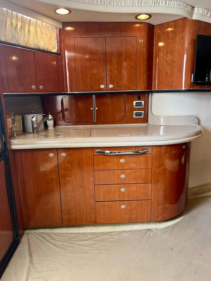 Slide: The Image of Luxurious kitchen area in a 2004 Sea Ray 46 Sundancer yacht with wooden cabinetry. - 6