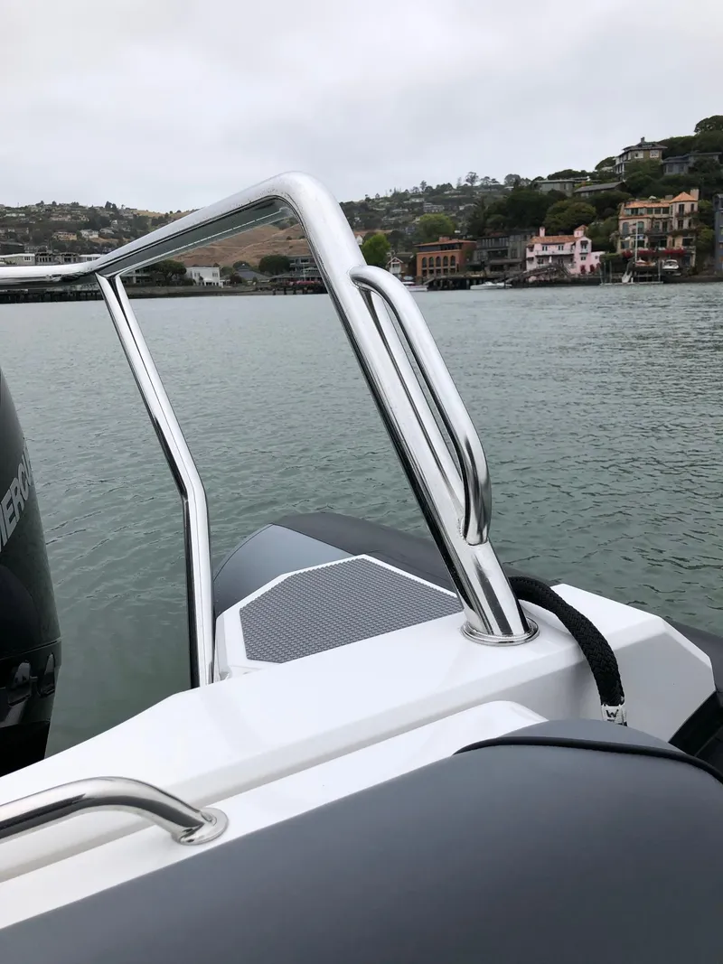 Slide: The Image of 2024 Protector 310 Targa boat on water, featuring sleek design and chrome railings. - 17