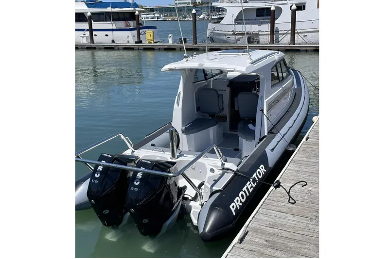 Slide: The Image of 2024 Protector 310 Targa boat docked, featuring dual V8 250 HP engines. - 2