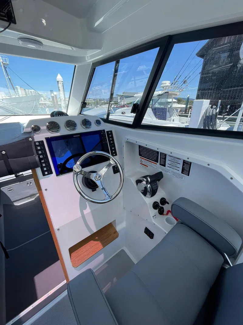 Slide: The Image of 2024 Protector 310 Targa boat cockpit with steering wheel and navigation controls. - 4