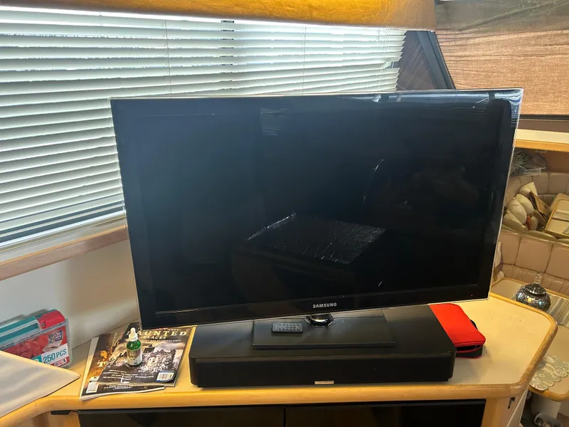 Slide: The Image of Television setup inside 1996 Carver 440 Aft Cabin Motor Yacht with magazines and decor. - 24