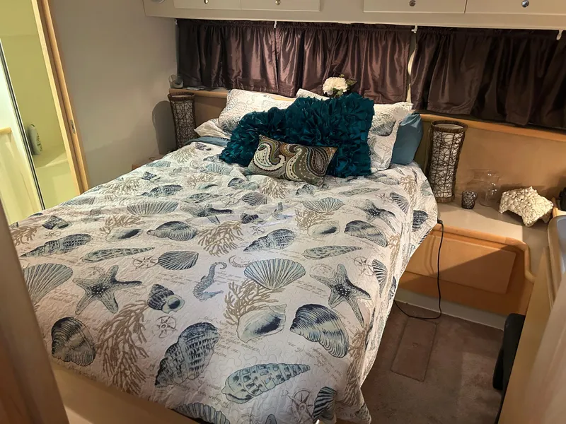 Slide: The Image of Cozy bedroom in 1996 Carver 440 Aft Cabin Motor Yacht with nautical-themed bedding. - 32