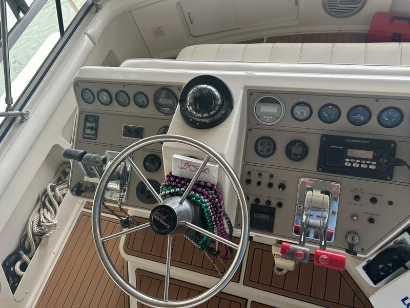Slide: The Image of 1996 Carver 440 Aft Cabin Motor Yacht helm with steering wheel and control panel. - 37