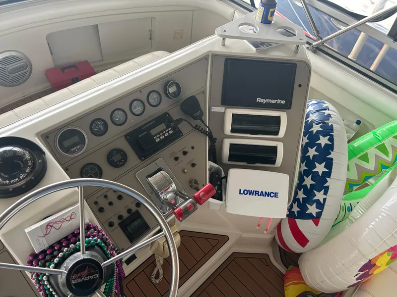 Slide: The Image of 1996 Carver 440 Aft Cabin Motor Yacht helm with navigation equipment and colorful inflatables. - 39