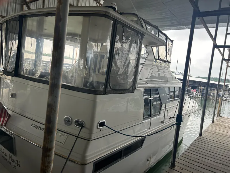 Slide: The Image of 1996 Carver 440 Aft Cabin Motor Yacht docked in a marina under a canopy. - 4